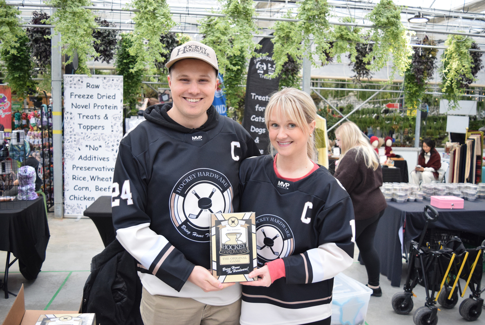 Billy (left) and Katherine Morrison (right) proudly display the hockey hardware game behind their booth at the market on Sunday, Jan. 25.